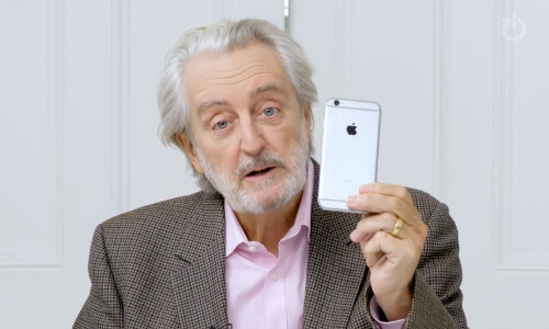 TV personality Paul Lewis holding up a mobile phone to camera