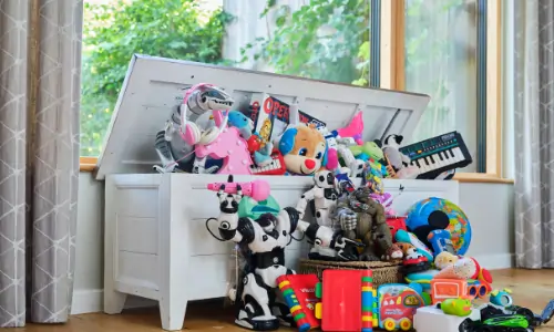 a large wooden box with a great quantity of electrical toys spilling out of it