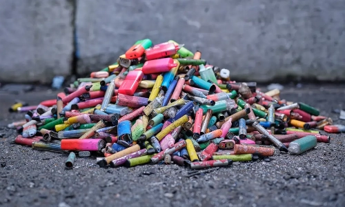 a close up of a pile of hundreds of discarded single use vapes