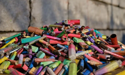 a close up of a pile of hundreds of discarded single use vapes