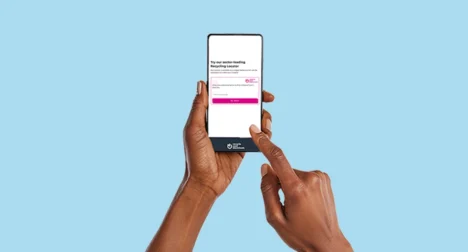 Two dark skinned hands using a mobile phone with the Recycle Your Electricals online widget, cutout on blue background