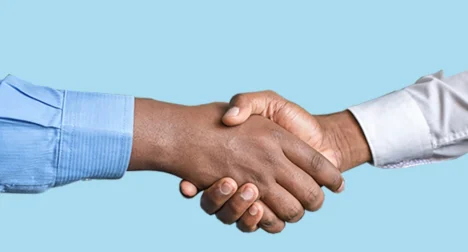 Photo shows two male dark skinned hands shaking, cutout on blue background